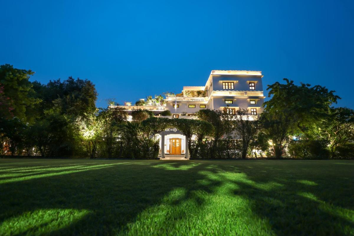 a large house on top of a lush green field at Saraca Hotel Lucknow in Lucknow