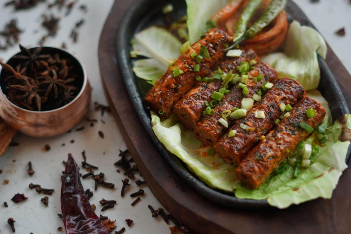 a plate of food with meat on top of lettuce at Radisson RED Chandigarh Mohali in Chandīgarh