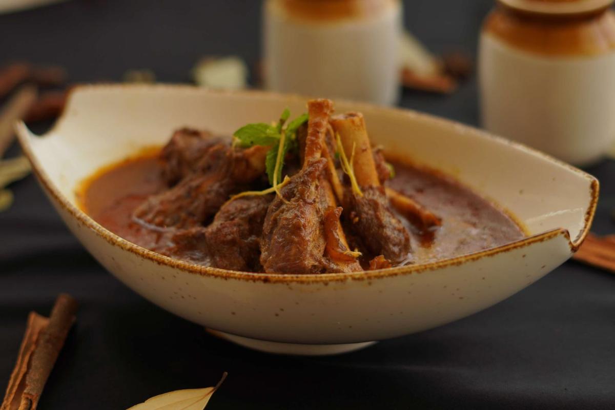 a bowl of soup with meat in it on a table at Radisson RED Chandigarh Mohali in Chandīgarh