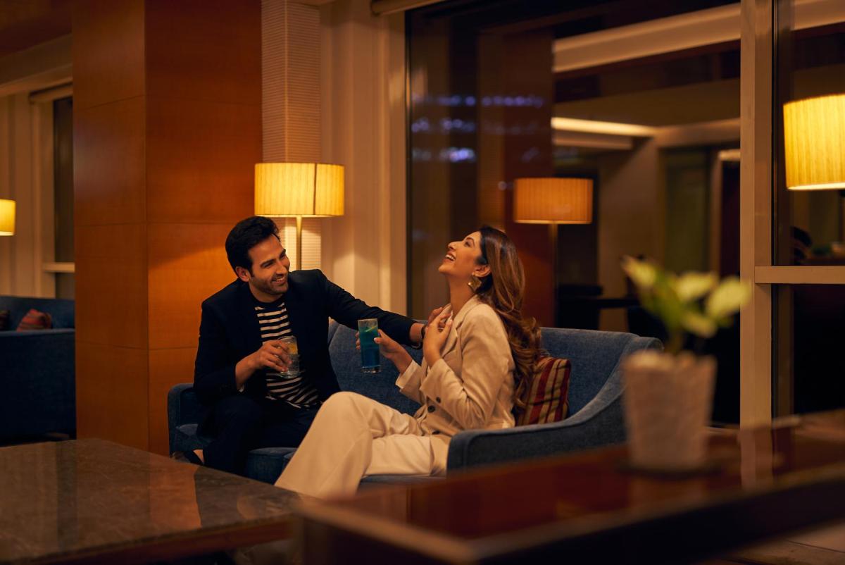 a man and a woman sitting in a room at Hyatt Regency Pune Hotel & Residences in Pune