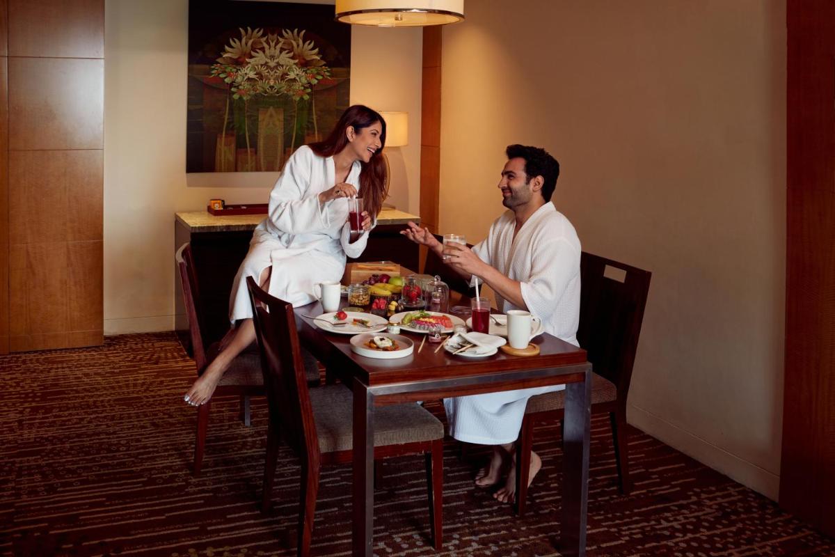 a man and woman sitting at a table eating food at Hyatt Regency Pune Hotel & Residences in Pune