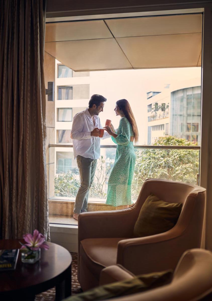 a man and a woman standing on a window at Hyatt Regency Pune Hotel & Residences in Pune