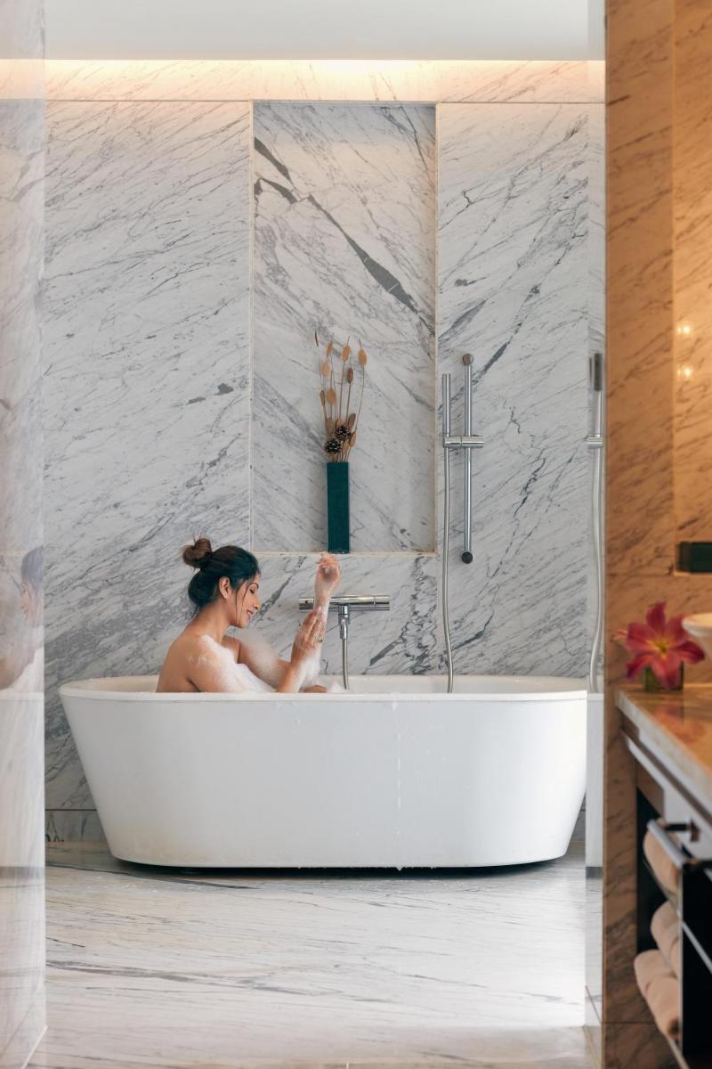 a woman sitting in a bath tub in a bathroom at Hyatt Regency Pune Hotel & Residences in Pune