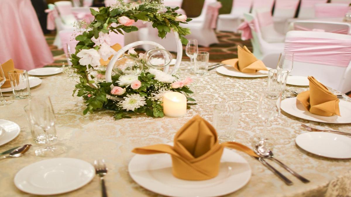 a table with white plates and flowers on it at Holiday Inn New Delhi Aerocity by IHG in New Delhi