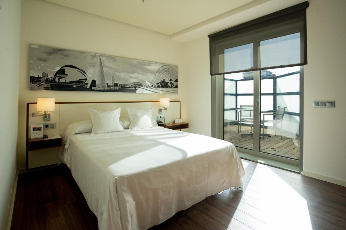 Un dormitorio con una gran cama blanca y una gran ventana. en Primus Valencia, en Valencia 70 fotos más