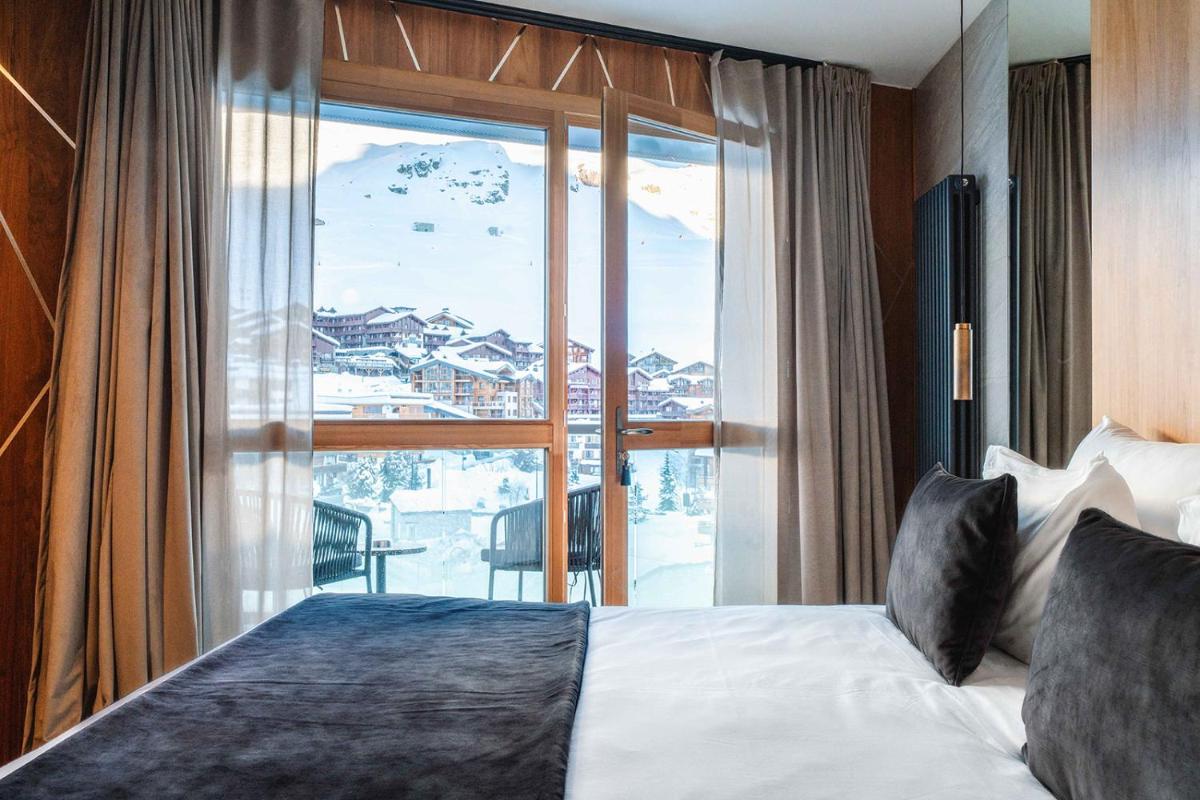 une chambre d'hôtel avec un lit et une grande fenêtre dans l'établissement Hôtel Le Diamond Rock, à Tignes