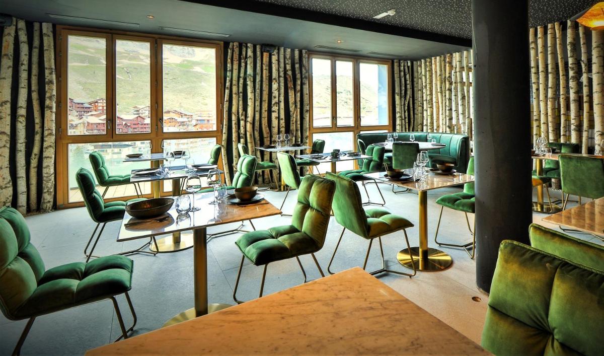 un restaurant avec des chaises vertes, des tables et des fenêtres dans l'établissement Hôtel Le Diamond Rock, à Tignes