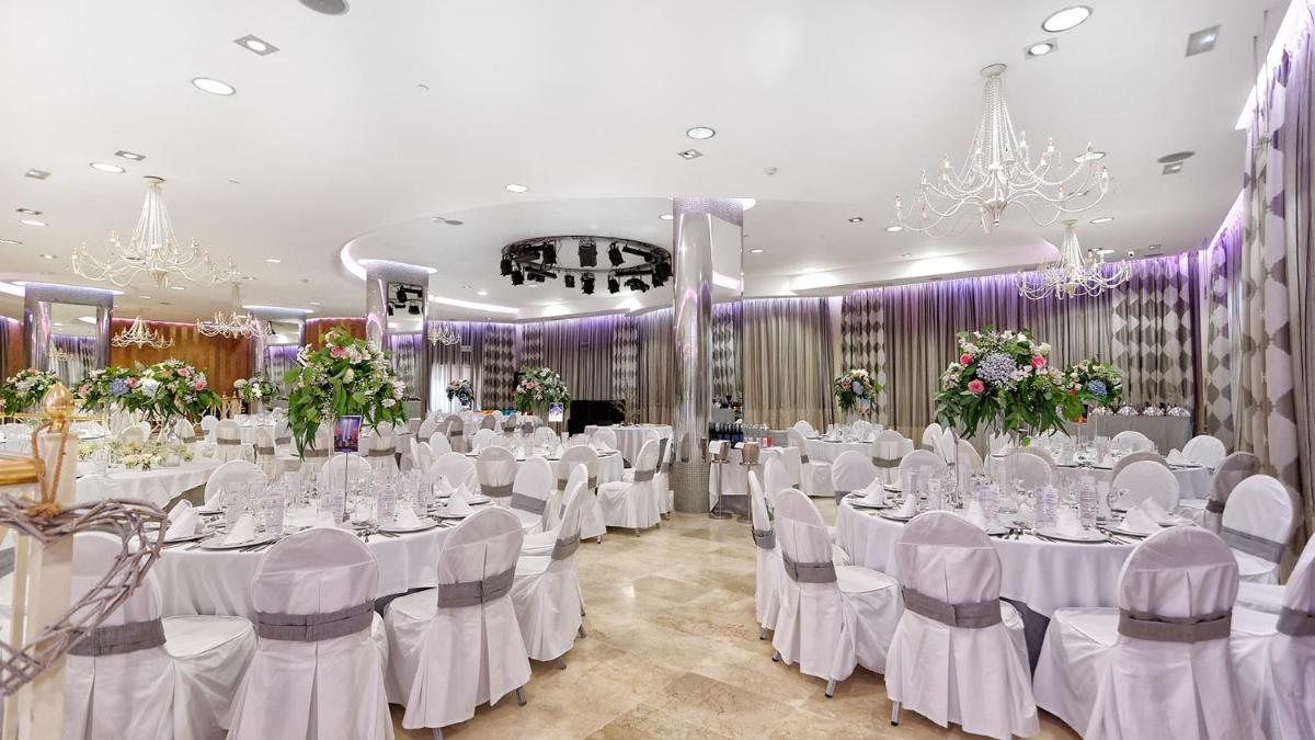 Un salón de banquetes con mesas y sillas blancas y candelabros. en Bull Reina Isabel & SPA, en Las Palmas de Gran Canaria 82 fotos más
