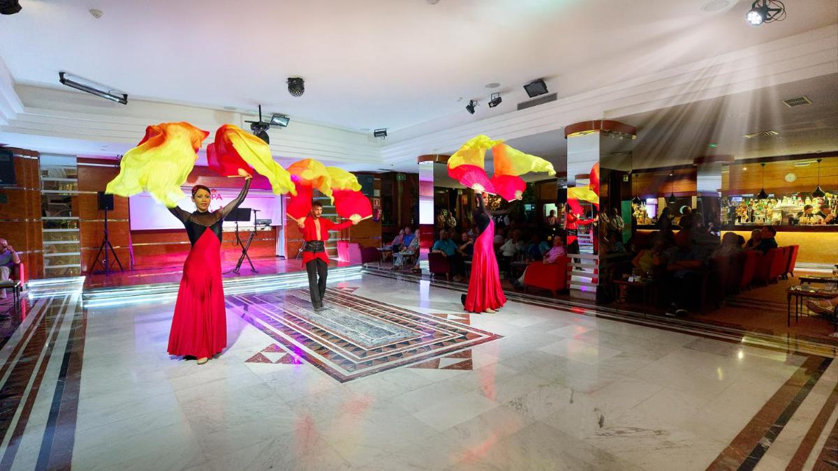 dos personas están de pie en una pista de baile con sombrillas en Bull Costa Canaria & SPA - Only Adults, en San Agustín 47 fotos más