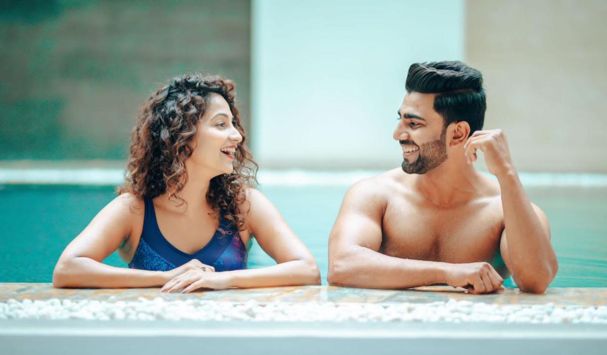 a man and woman laying in a swimming pool at Hyatt Regency Pune Hotel & Residences in Pune