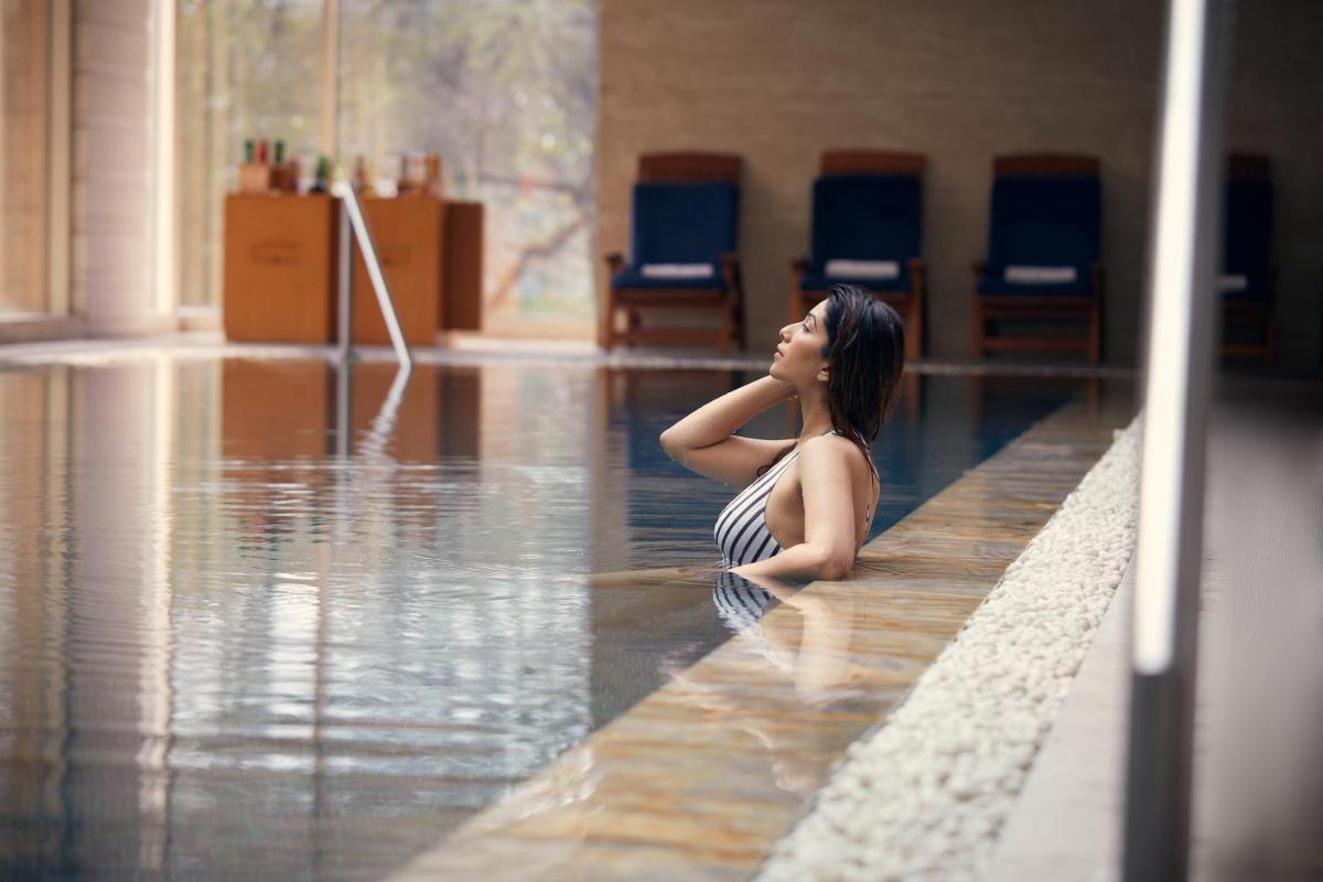 a woman sitting in the water in a swimming pool at Hyatt Regency Pune Hotel & Residences in Pune
