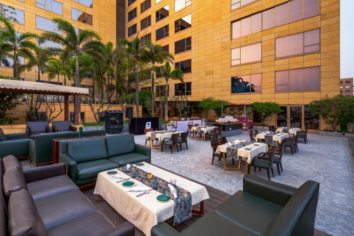 an outdoor patio with tables and couches and restaurants at Hyatt Regency Pune Hotel & Residences in Pune