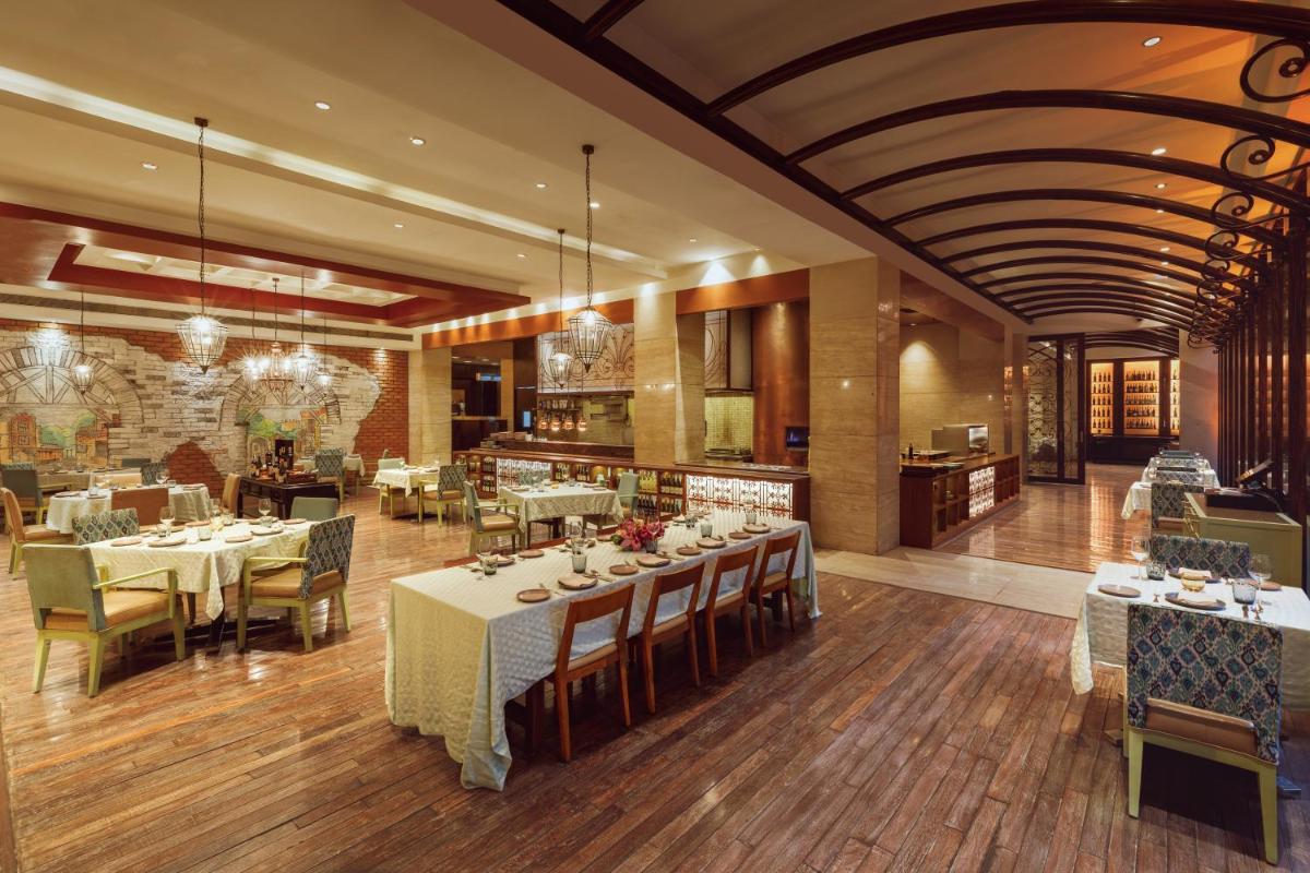 a restaurant with tables and chairs in a room at Hyatt Regency Pune Hotel & Residences in Pune
