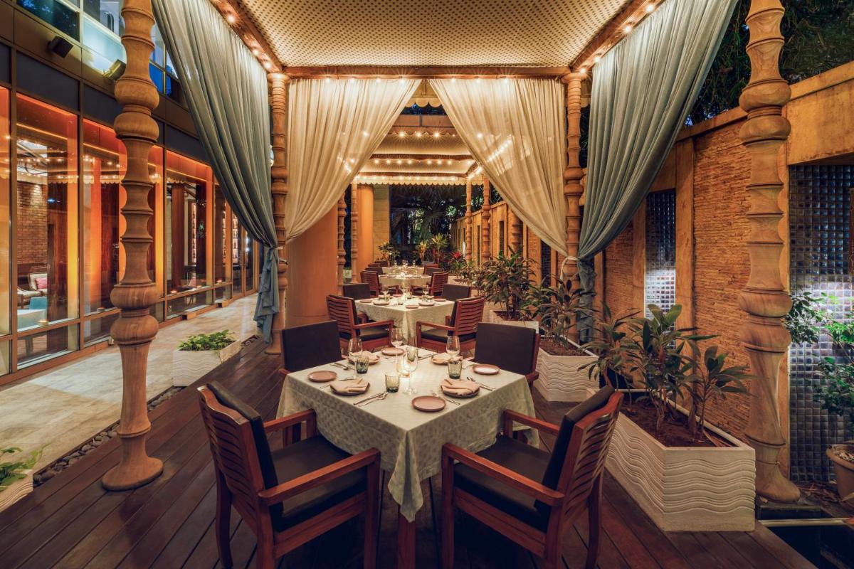 a dining room with a table and chairs at Hyatt Regency Pune Hotel & Residences in Pune