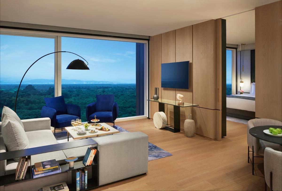 a living room with a couch and a tv at Taj The Trees, Mumbai in Mumbai