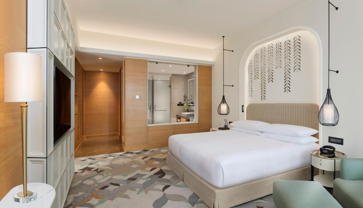 a bedroom with a white bed and a bathroom at InterContinental Jaipur Tonk Road by IHG in Jaipur