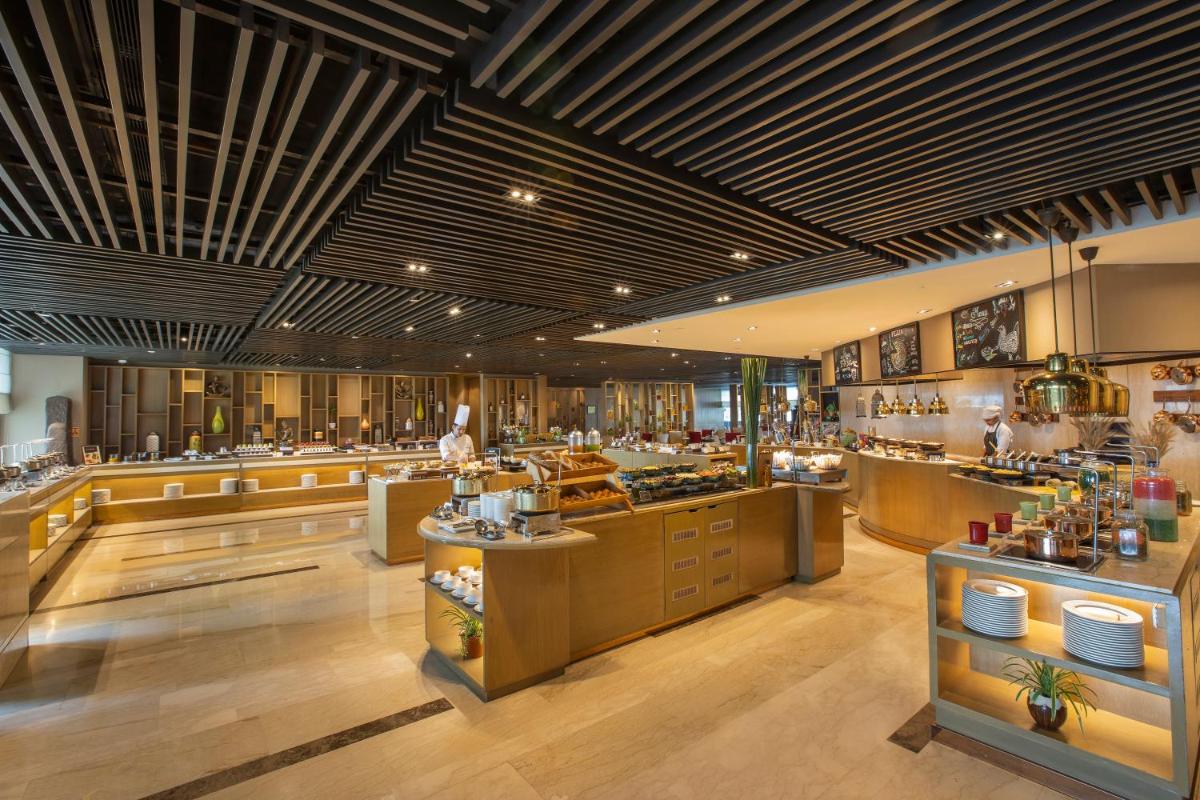 a restaurant with aasteryasteryasteryasteryasteryasteryasteryasteryasteryasteryasteryastery at The Leela Ambience Convention Hotel Delhi in New Delhi