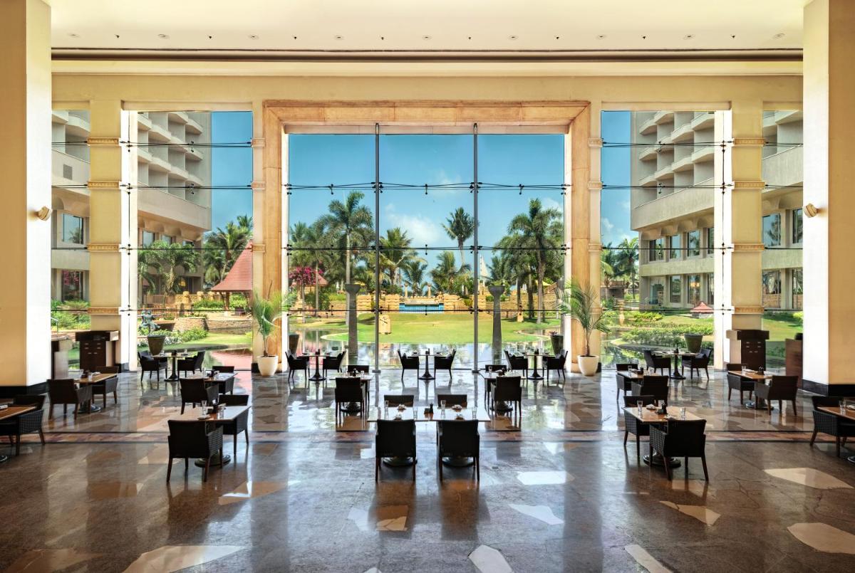 a large lobby with tables and chairs and a large window at JW Marriott Mumbai Juhu in Mumbai a large lobby with tables and chairs and a large window at JW Marriott Mumbai Juhu in Mumbai