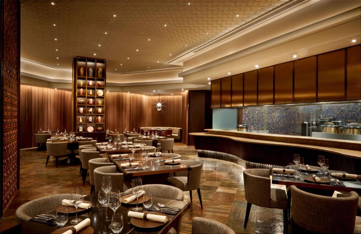 a restaurant with tables and chairs and a bar at JW Marriott Mumbai Juhu in Mumbai