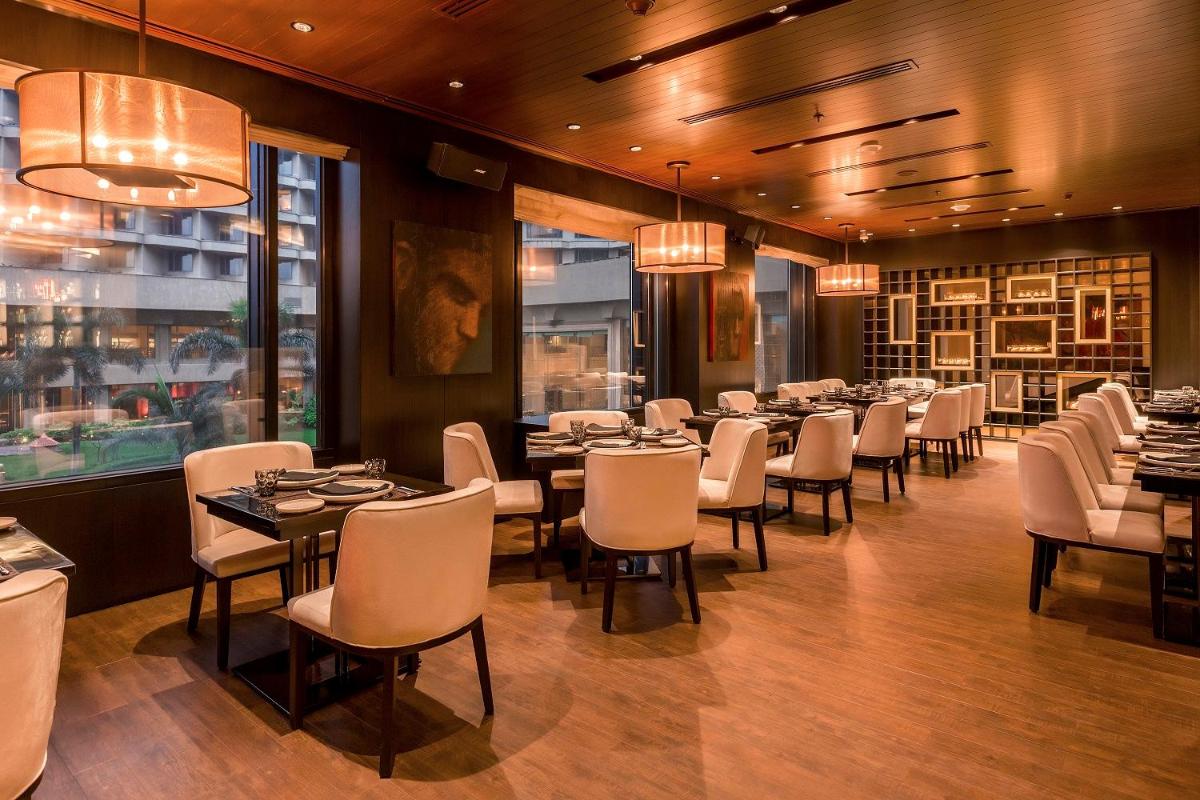 a dining room with tables and chairs in a restaurant at JW Marriott Mumbai Juhu in Mumbai