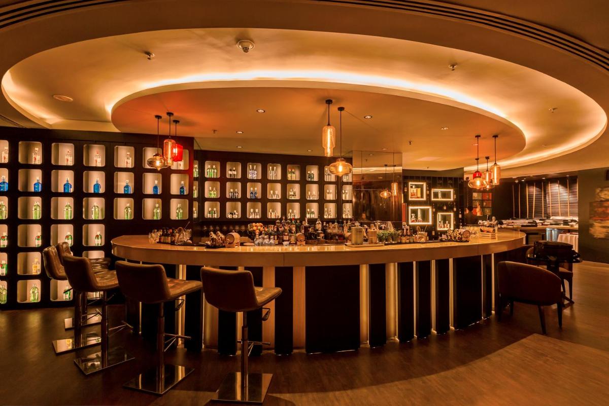 a bar in a restaurant with a large counter at JW Marriott Mumbai Juhu in Mumbai