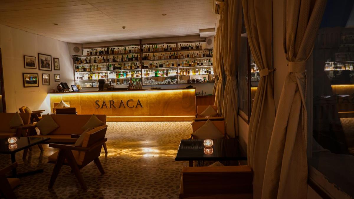 a restaurant with a bar with a sign that reads sarma at Saraca Hotel Lucknow in Lucknow