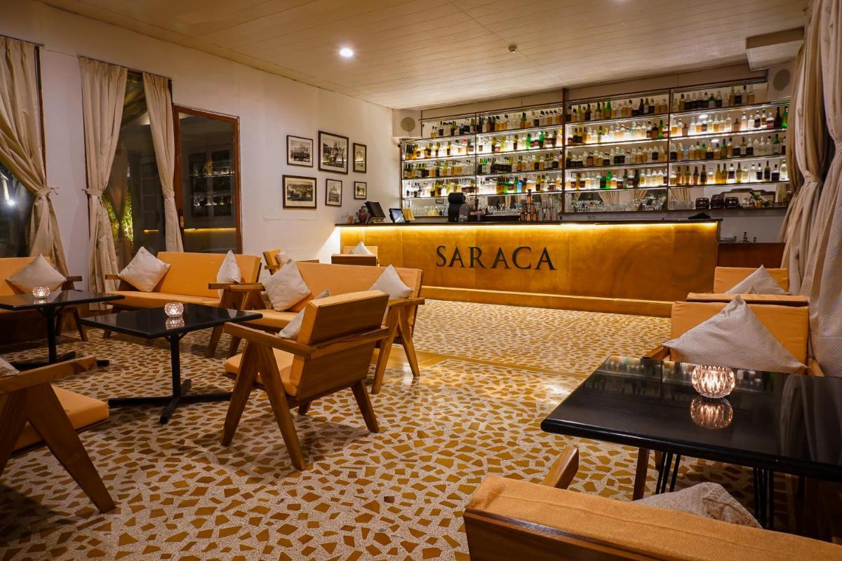 a restaurant with couches and tables in front of a store at Saraca Hotel Lucknow in Lucknow