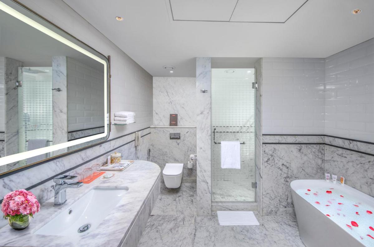 a bathroom with a tub and a sink and a toilet at Welcomhotel by ITC Hotels, Cathedral Road, Chennai in Chennai