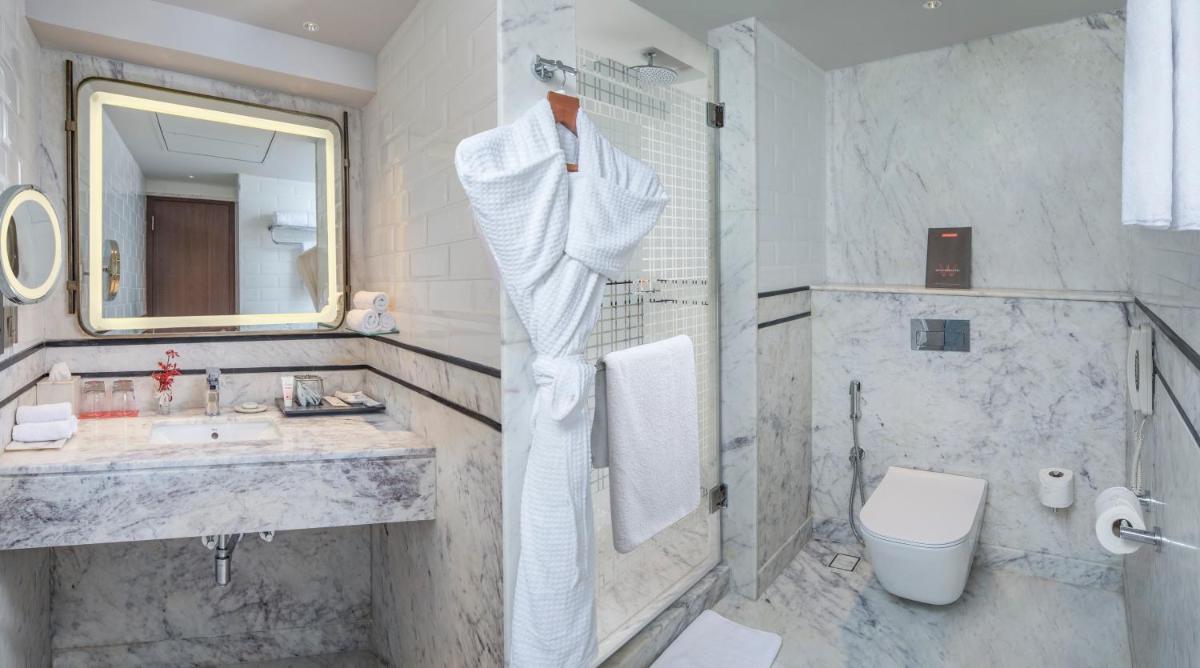 a white bathroom with a sink and a toilet at Welcomhotel by ITC Hotels, Cathedral Road, Chennai in Chennai