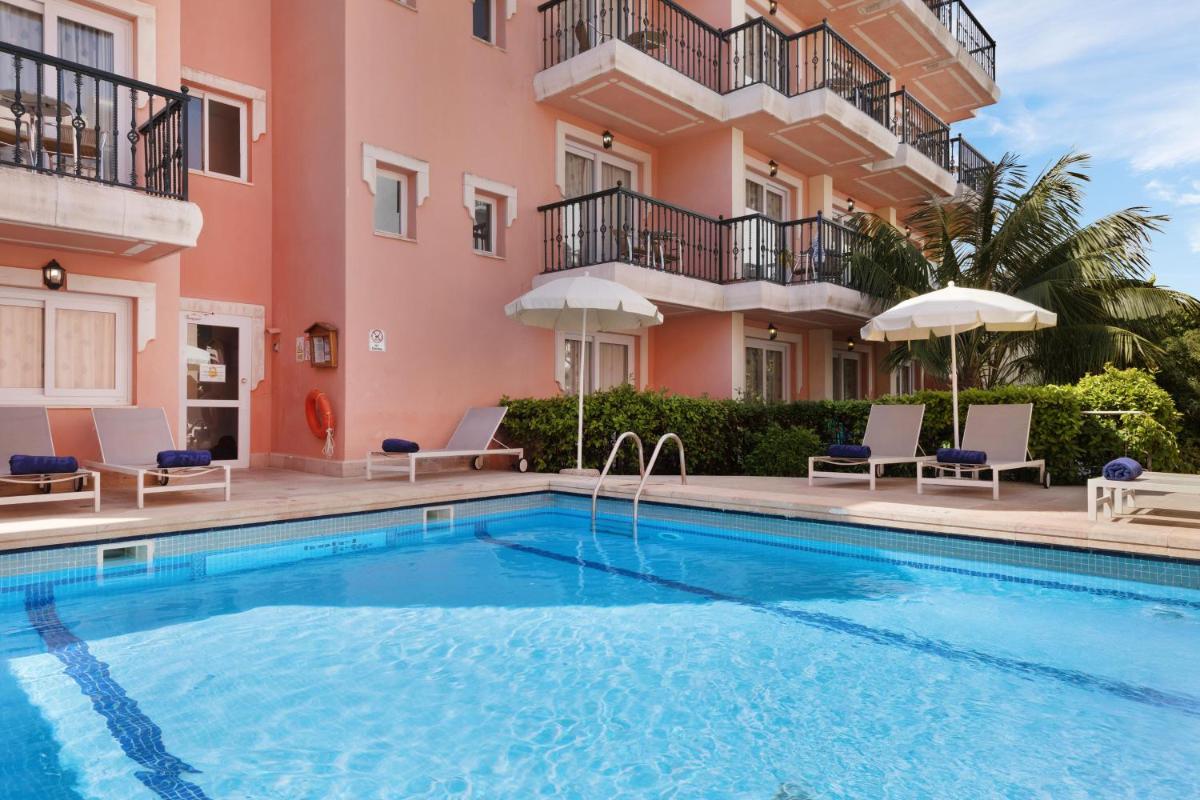 una villa con piscina frente a un edificio en THB Felip - Adults Only, en Porto Cristo
