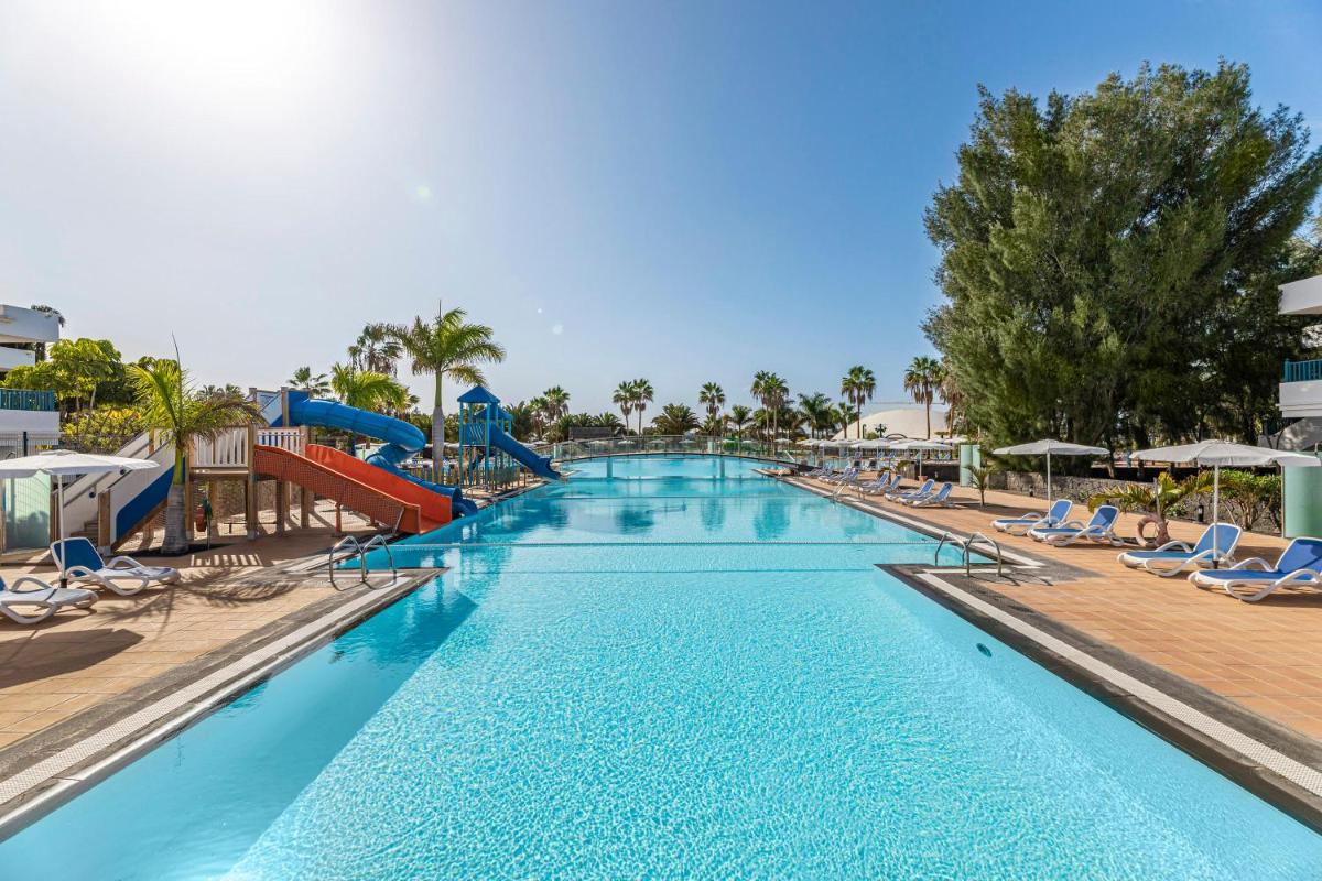 una gran piscina con tobogán y sillas en THB Tropical Island, en Playa Blanca