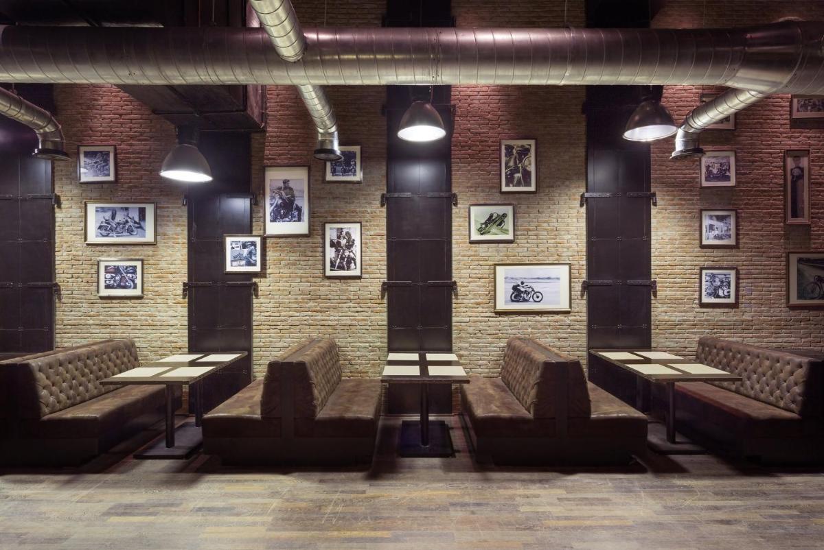 a room with benches and pictures on a brick wall at Holiday Inn Jaipur City Centre by IHG in Jaipur a room with benches and pictures on a brick wall at Holiday Inn Jaipur City Centre by IHG in Jaipur