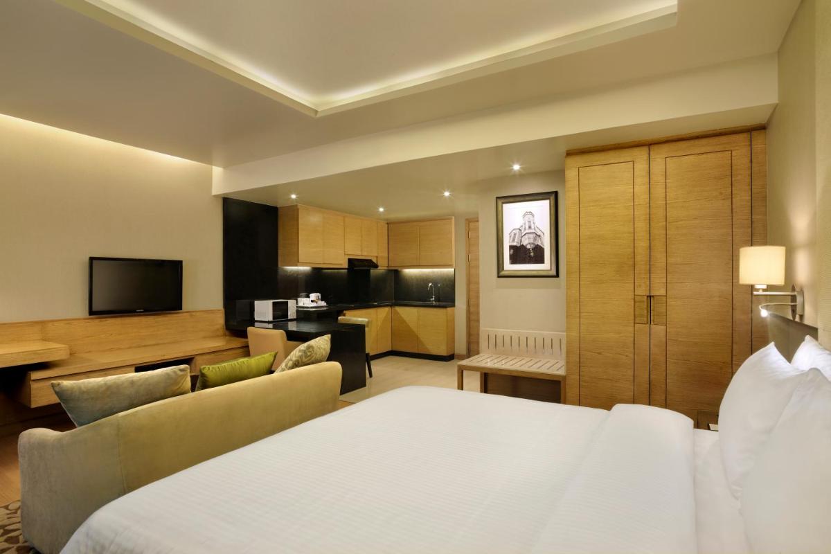 a hotel room with a bed and a kitchen at DoubleTree Suites by Hilton Bengaluru Outer Ring Road in Bengaluru