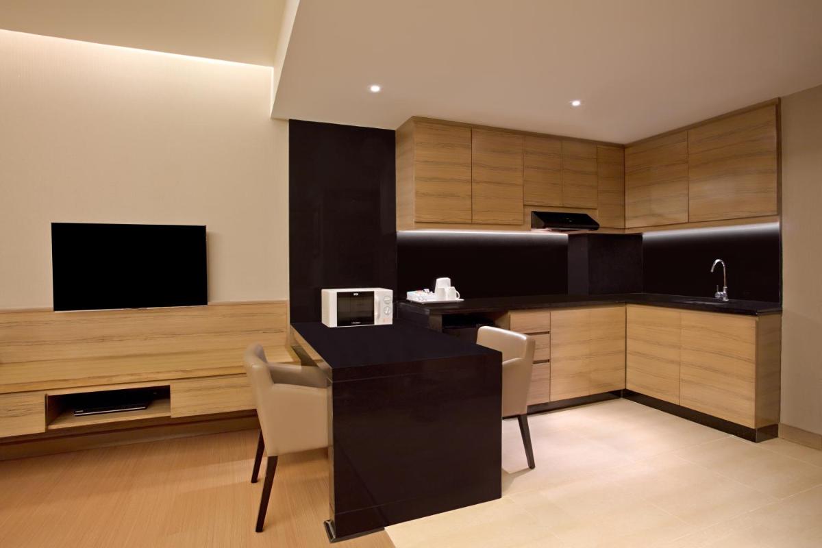 a kitchen with a table and chairs and a television at DoubleTree Suites by Hilton Bengaluru Outer Ring Road in Bengaluru