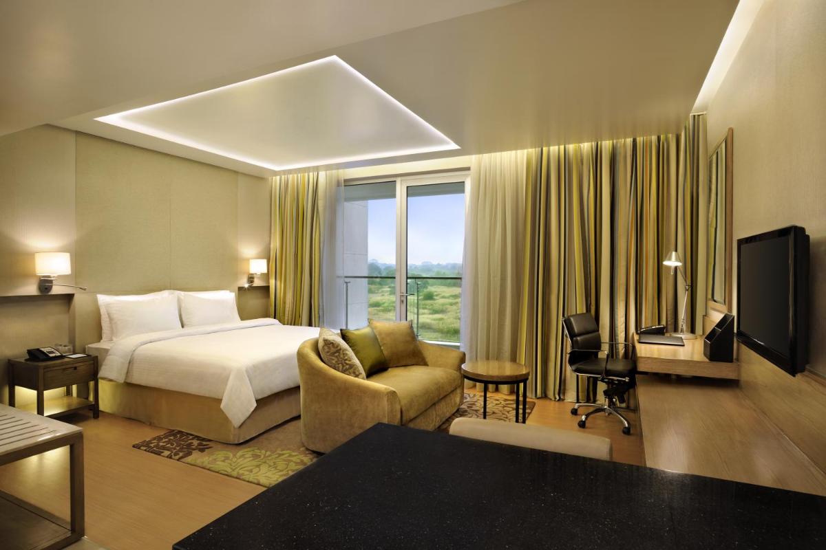 a hotel room with a bed and a television at DoubleTree Suites by Hilton Bengaluru Outer Ring Road in Bengaluru
