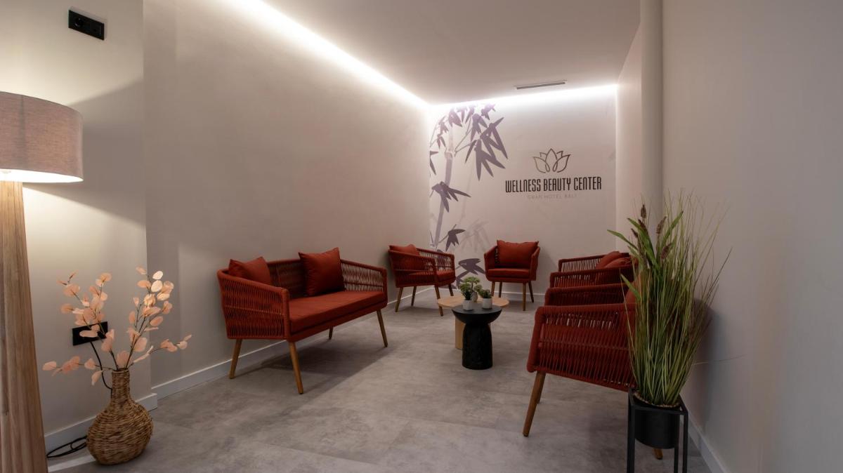 una sala de espera con sillas rojas y un cartel en la pared en Gran Hotel Bali & Spa, en Benidorm