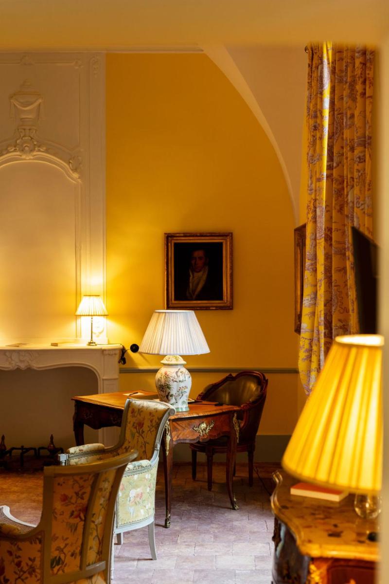 une salle à manger avec une table et deux lampes dans l'établissement Château de Collias, à Collias