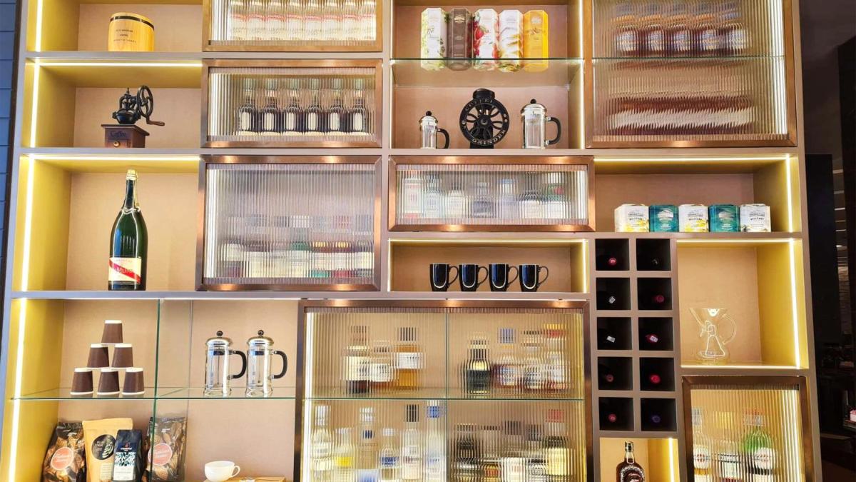 a display case filled with lots of bottles and glasses at InterContinental Jaipur Tonk Road by IHG in Jaipur