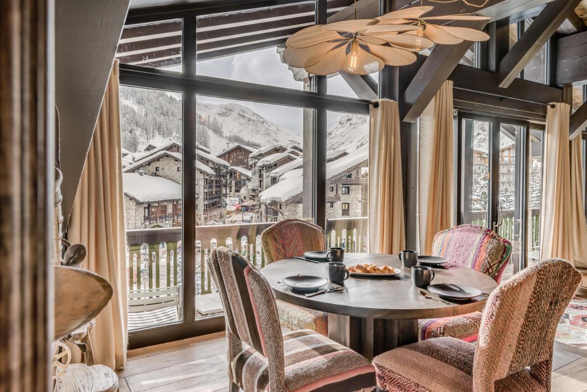une salle à manger avec une table et des chaises et une grande fenêtre dans l'établissement Hotel & Spa Le Val d'Isère, à Val dʼIsère