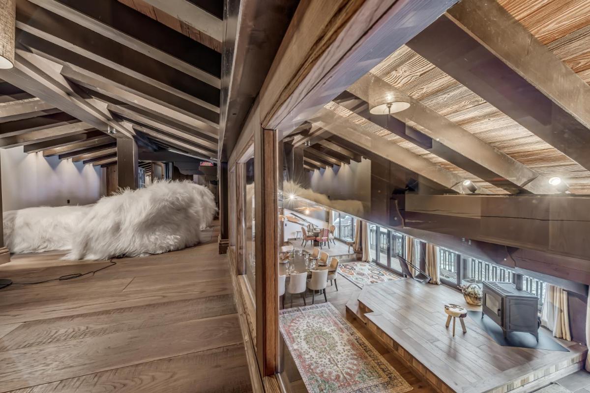 - un salon avec un grand chien blanc posé sur le sol dans l'établissement Hotel & Spa Le Val d'Isère, à Val dʼIsère