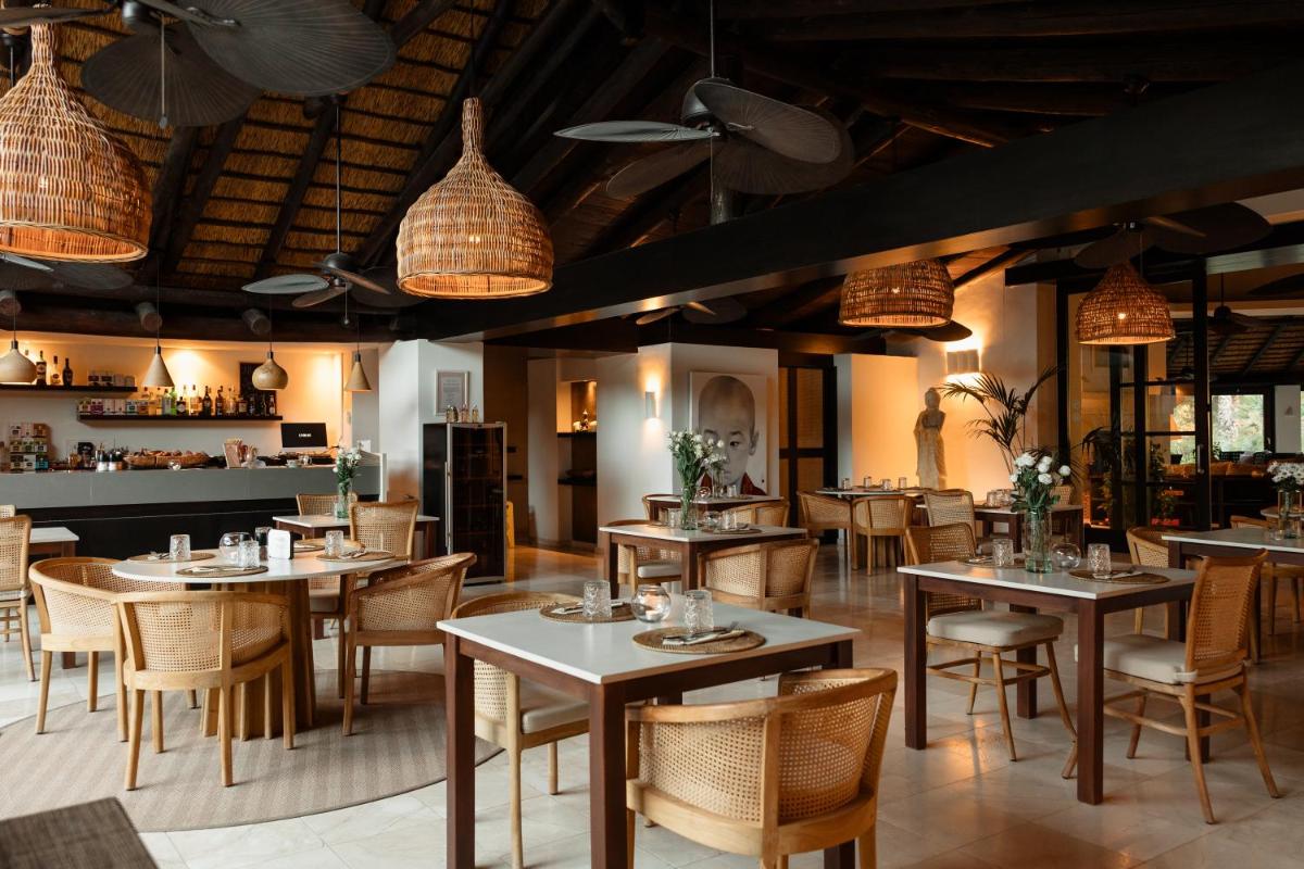 Un restaurante con mesas, sillas y luces. en Shanti Som, en Monda