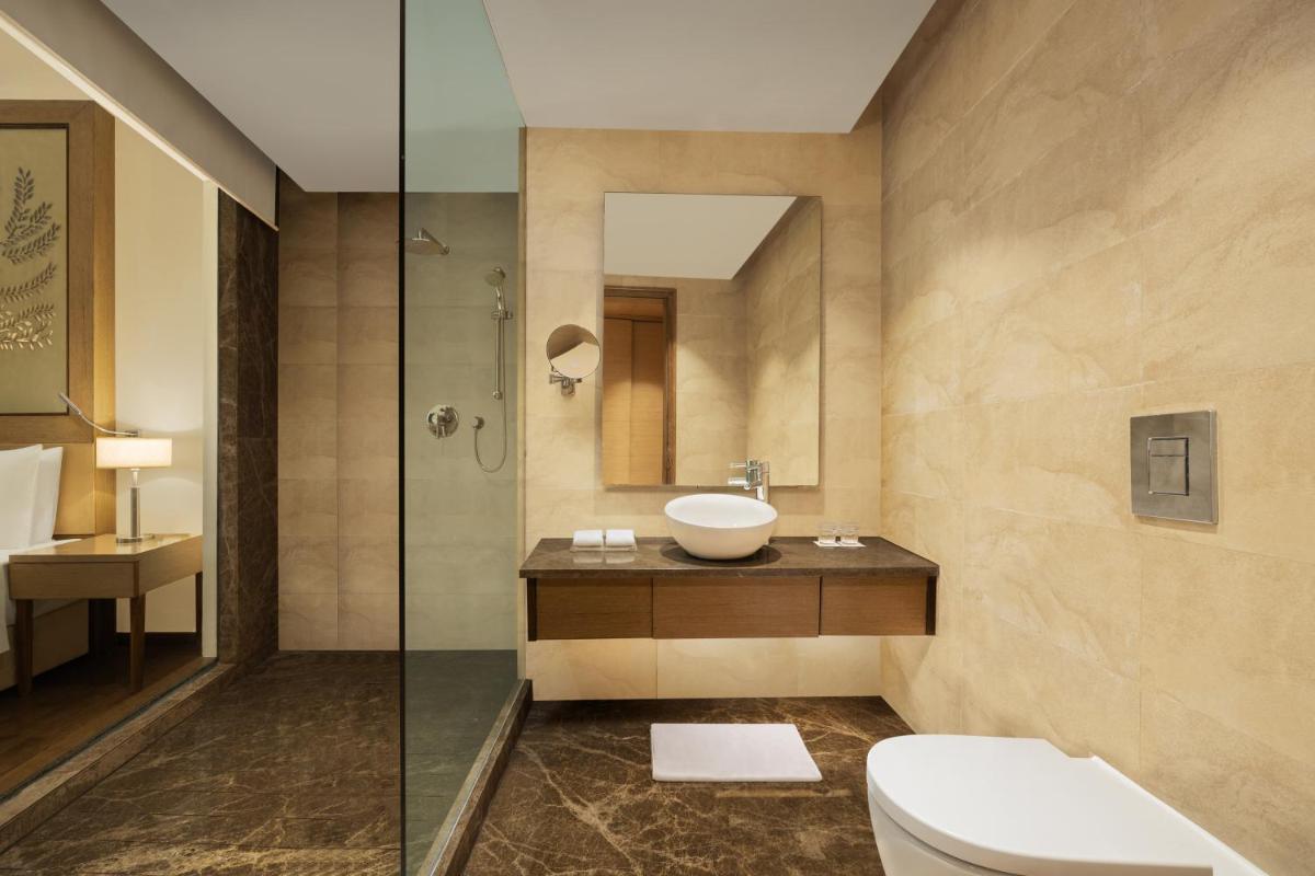 a bathroom with a toilet and a sink and a shower at Radisson Blu Hotel New Delhi Dwarka in New Delhi a bathroom with a toilet and a sink and a shower at Radisson Blu Hotel New Delhi Dwarka in New Delhi
