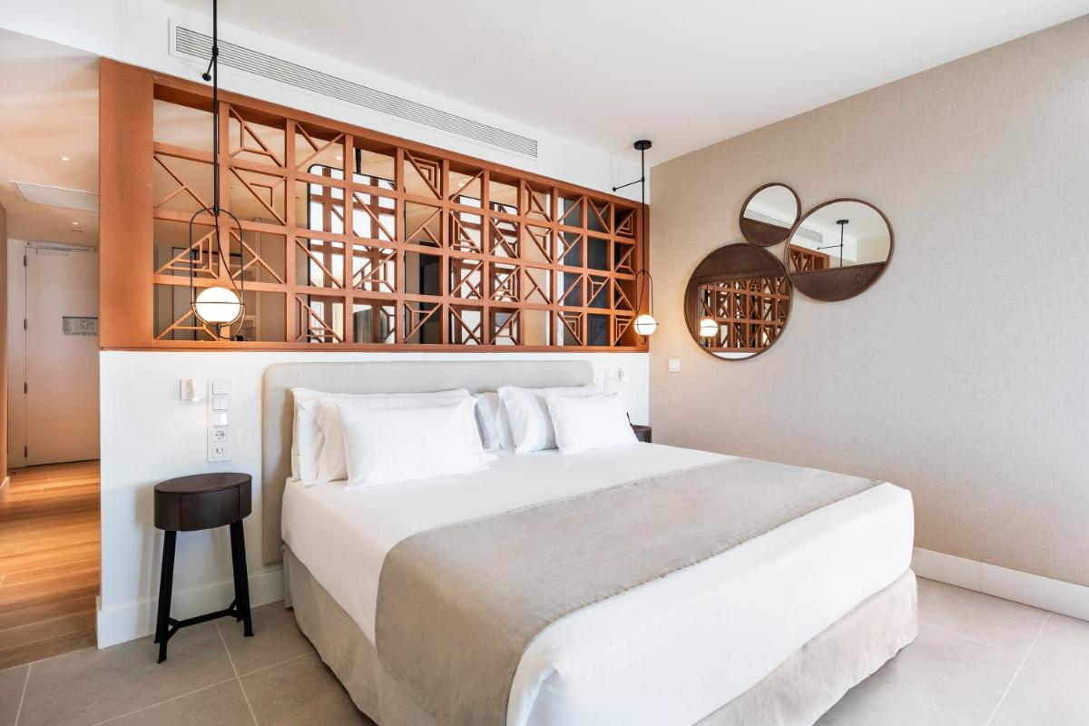 Un dormitorio con una gran cama blanca y dos lámparas. en Barceló Playa Blanca, en Playa Blanca
