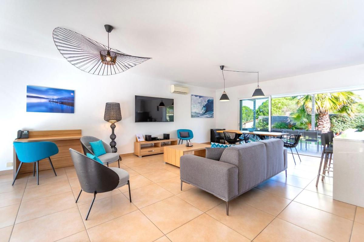 un salon avec un canapé et des chaises dans l'établissement Domaine Villas Mandarine Private Pools & Spa, à Calvi