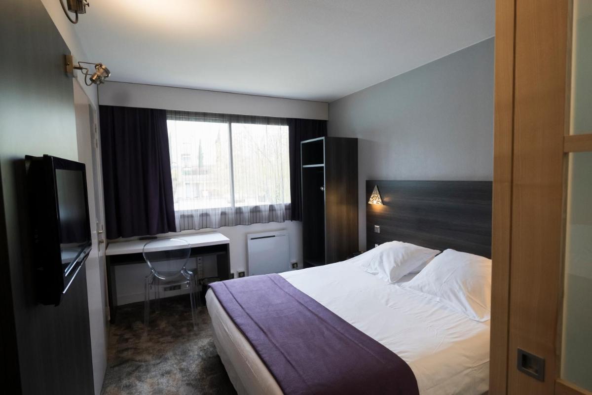 Un ou plusieurs lits dans un hébergement de l'établissement Logis Hotel Restaurant SPA Les Oliviers
