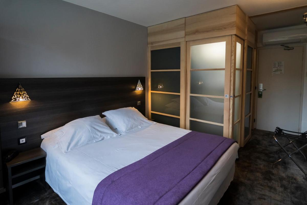 Un ou plusieurs lits dans un hébergement de l'établissement Logis Hotel Restaurant SPA Les Oliviers
