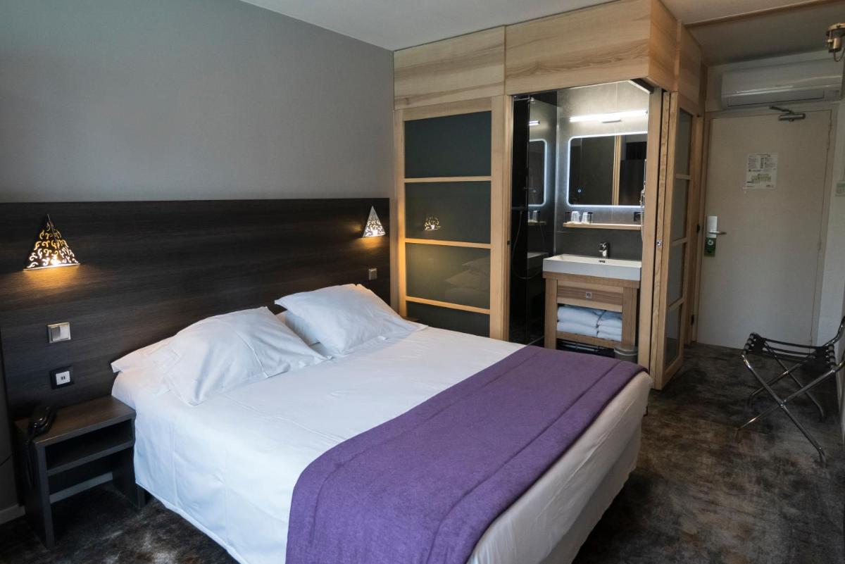Un ou plusieurs lits dans un hébergement de l'établissement Logis Hotel Restaurant SPA Les Oliviers
