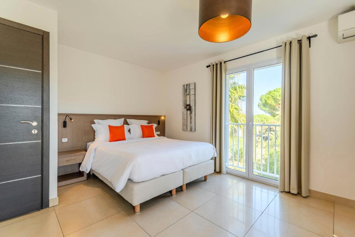 une chambre avec un lit et une grande fenêtre dans l'établissement Domaine Villas Mandarine Private Pools & Spa, à Calvi