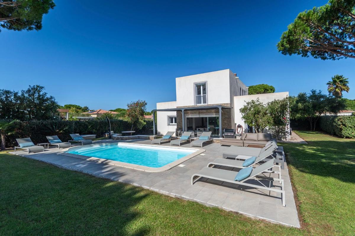 une villa avec piscine et chaises longues dans l'établissement Domaine Villas Mandarine Private Pools & Spa, à Calvi