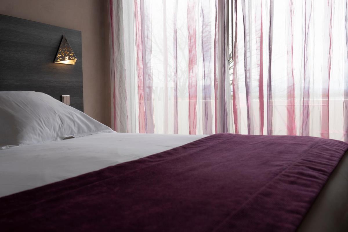 Un ou plusieurs lits dans un hébergement de l'établissement Logis Hotel Restaurant SPA Les Oliviers